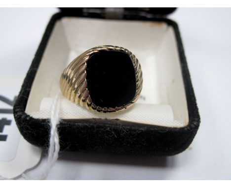 A 9ct Gold Gent's Signet Ring, the black onyx panel rubover set between reeded tapering shoulders.