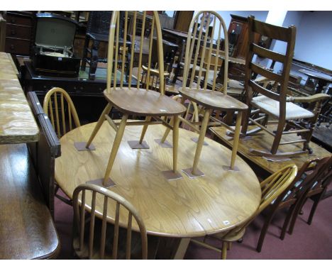 An Ercol Light Ash/Elm Oval Topped Drop Leaf Dining Table, on slender waisted supports, 131 x 127cm.