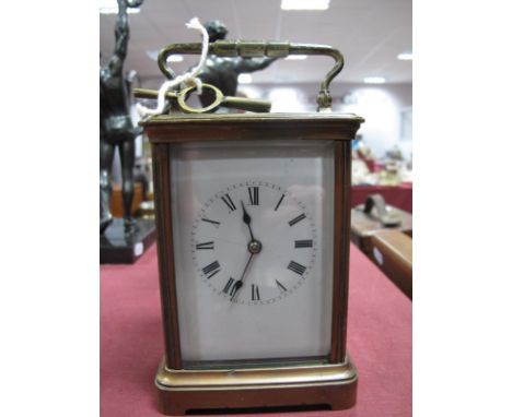 An Early XX Century Brass Cased Carriage Clock, with fluted sides and bracket feet, the white enamel dial with Arabic numeral
