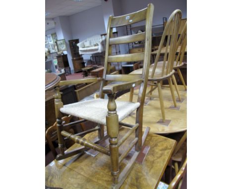 A Stained Beech Country Made Rocking Chair, with ladder back, rush seat  and turned front stretcher.