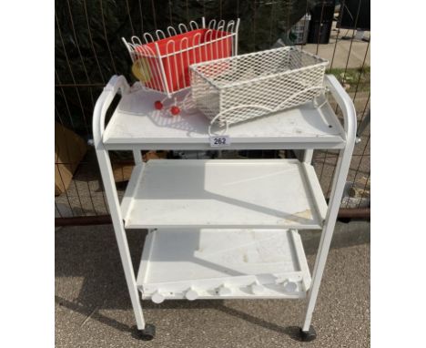 A white metal 3 shelf beauticians style trolley and two small planters