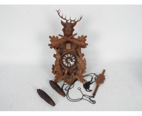 A vintage cuckoo clock with pendulum and twin weights.