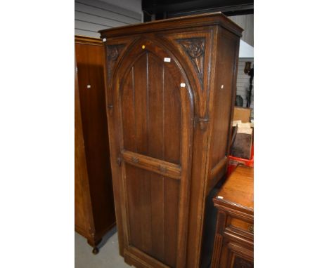 An early 20th Century oak hall robe or wardrobe in the Gothic design with carved rosette decoration, internal mirror and trin