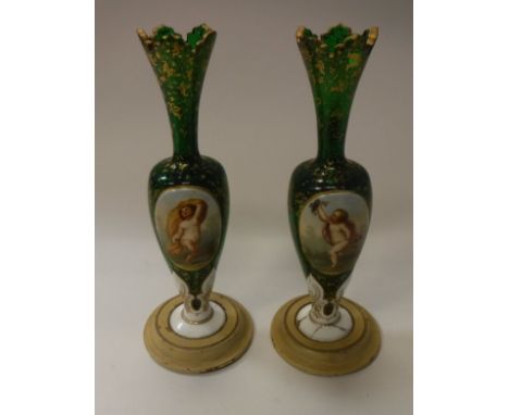 A pair of 19th Century Bohemian green glass vases with white enamel plaques decorated with floral sprays and cherubic figures