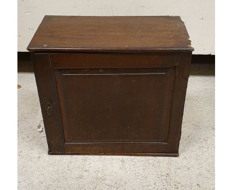 A 19th Century mahogany miniature cupboard with fielded panel door enclosing a bank of eight drawers, together with a cut gla