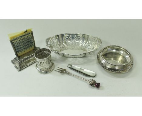 A silver mounted desk calendar, a silver bonbon dish with pierced decoration (by William Comyns, London 1928), a silver table