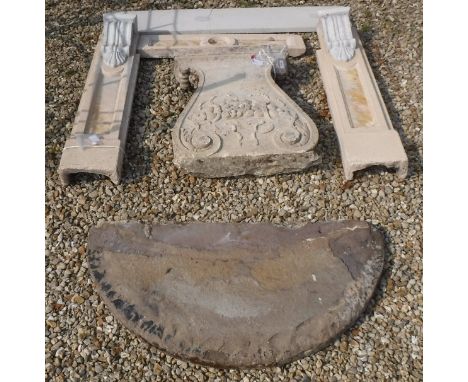 A natural stone demi-lune console table on later fruit decorated base and a simulated natural stone and Sienna marble fire su