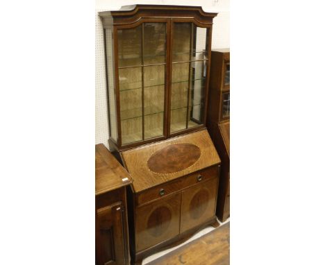 An Edwardian mahogany and inlaid bureau bookcase, the upper section with two glazed and barred doors enclosing adjustable gla