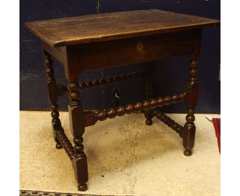 A 18th Century oak side table the plank top with cleated ends over a single drawer on bobbin turned supports united by stretc