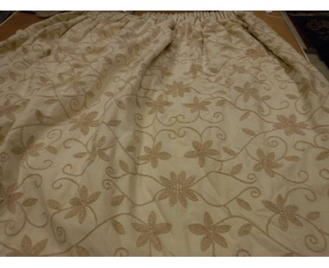 A pair of cotton type cream ground crewel work style decorated interlined curtains with tape, pencil pleat headings and match