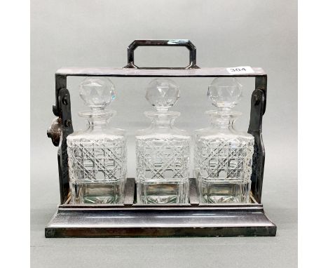 A silver plated three bottle cut crystal tantalus, W. 35cm.