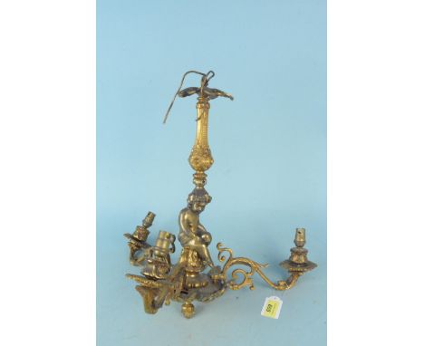 An antique solid brass three branch candelabra with cherubs