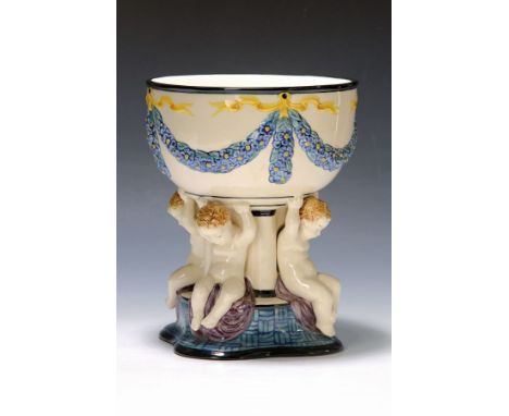 Pokal mit 4 Putten, Karlsruher Majolika, um 1910-23,  Modellnr. 1156, Entwurf Süs, die vollplastischen Putten halten die Scha