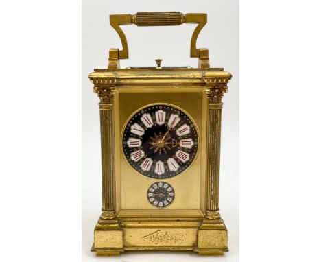 A late 19th century brass repeating carriage clock with alarm function, enamelled dial and subsidiary dial flanked by columns