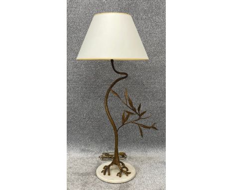 A gilt metal floor standing standard lamp in the form of a stylised branch or tree, on a marble base and with shade. H.106cm