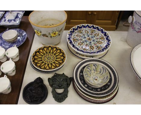 A collection of Greek, Turkish and other pottery plates; a hanging face mask; a floral decorated planter etc.
