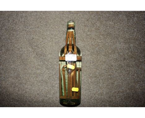 A glass bottle containing preserved wooden tools