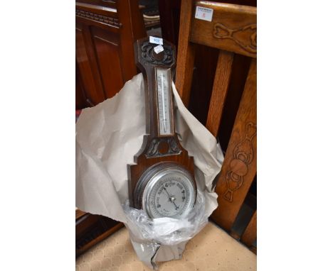 An early 20th Century oak cased barometer of typical design having thermometer dial