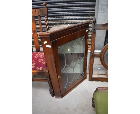 An Edwardian corner cupboard having leaded light glazed door