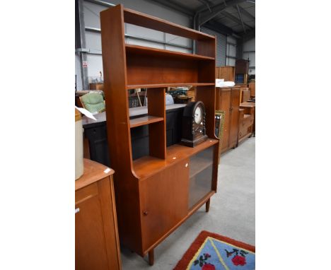 A vintage teak shelf unit having open shelves over sliding glass/solid doors, width approx. 106cm