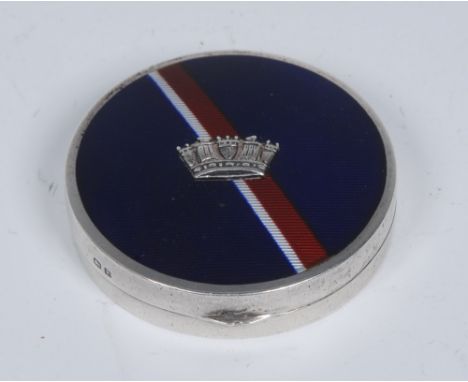 A George V silver and enamel rouge compact, hinged cover decorated with a red and white sash on a bleu royale ground and appl