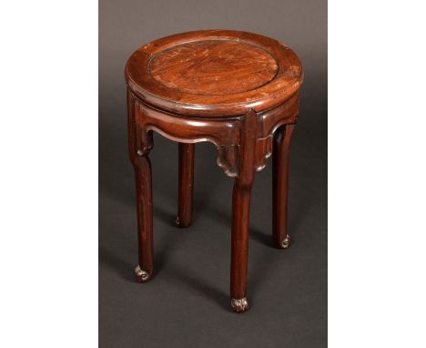 A Chinese padouk wood circular jardiniere stand, panelled top above a shaped frieze, scroll feet, 52cm high, 36cm diam, early