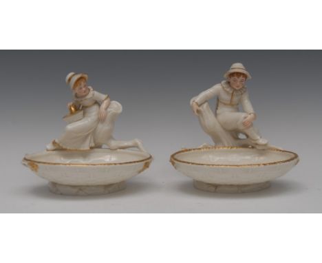 A pair of Royal Worcester figural sweetmeat dishes, modelled by James Hadley, after Kate Greenaway, in the white picked out i