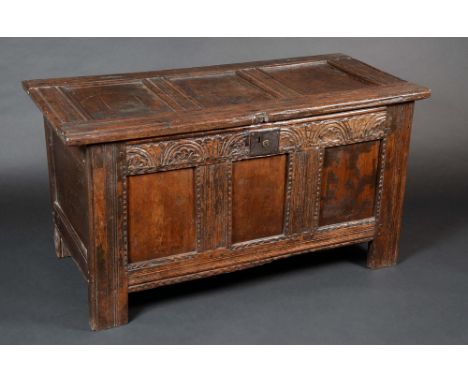 A Charles II oak three-panel blanket chest, hinged top, lunette carved frieze, stile feet incised with meandering bands and l