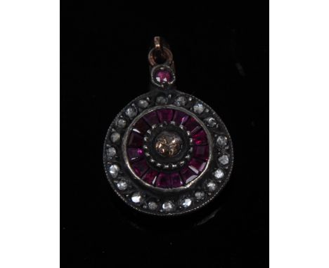 A diamond and ruby target pendant, central old cut diamond, approx 0.20ct, surrounded by a stepped band of fifteen trapezoid 