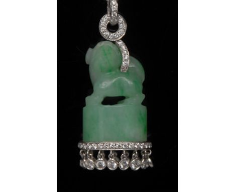 A jade and diamond foo dog pendant, diamond drop ring and suspension loop supporting a carved jade foo dog, above a solid ban