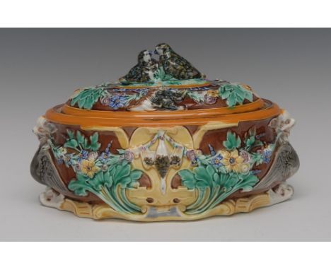 A Wedgwood majolica oval game pie tureen and cover, moulded in relief with  floral swags, dead game tendrils, winged mystical