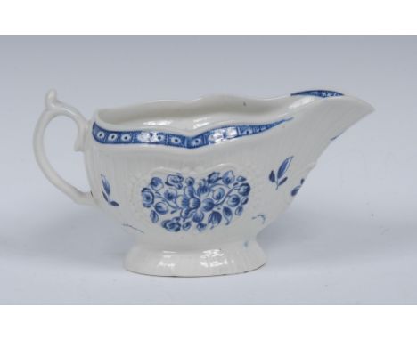 A Worcester sauceboat, painted in underglaze blue with sprays of flowers, moulding with strap flutes and Rococo cartouches, o