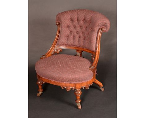 A Victorian walnut salon tub chair, button back, stuffed-over upholstery, turned legs carved with scrolling acanthus, ceramic