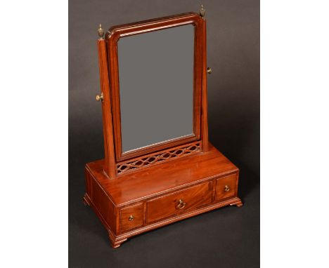 A 'George II' mahogany dressing-glass, the rounded rectangular tilting plate with incurved upper angles above a fretwork apro