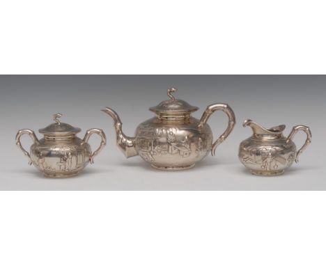 A Chinese silver three-piece tea service, comprising teapot, sucrier and cover and milk jug,  each embossed with oriental fig