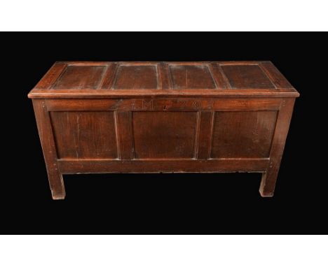 An early 18th century oak blanket chest, hinged four-panel top above a three-panel front, stile feet, 71cm high, 140cm wide, 