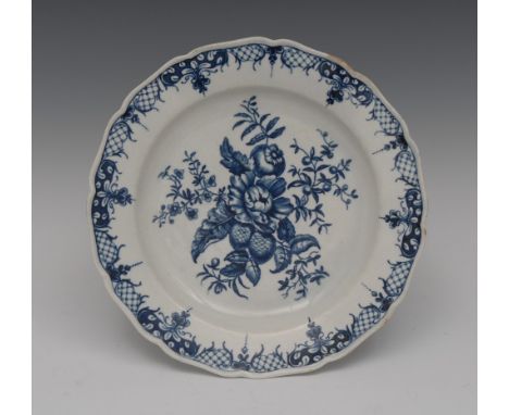 A Worcester Pomegranate pattern shaped circular plate, printed in underglaze blue with peony, pine cones and foliage, trellis