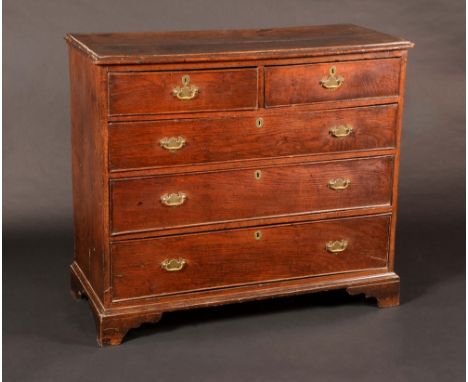 A mid-18th century oak chest of two short and three long graduated cockbeaded drawers, brass bat shaped handles and oval escu