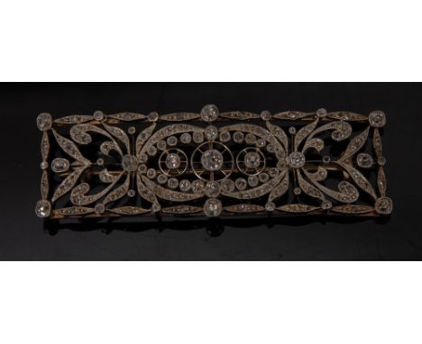 An Art Deco style diamond panel brooch, open scrolling body pave encrusted with round and old cut diamonds, total estimated d
