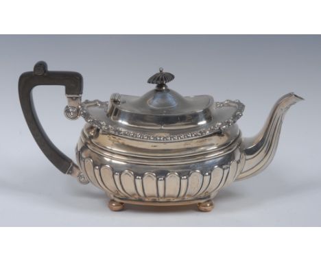 A George V silver half fluted boat shaped teapot, rectangular knop finial, hinged domed cover, gadrooned border with shells a