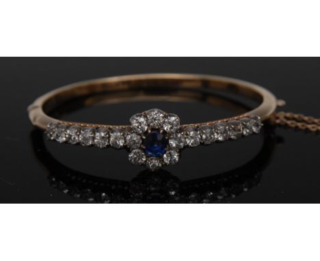 A fine sapphire and diamond hinge bangle,  set with a floral cluster of central blue sapphire approx 0.75ct, surround by a ba