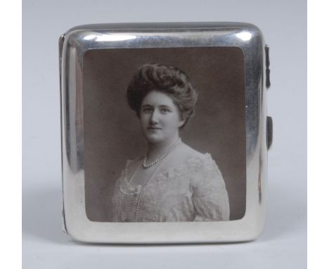 An Edwardian silver and enamel curved rounded rectangular cigarette case, hinged cover decorated with a photographic portrait