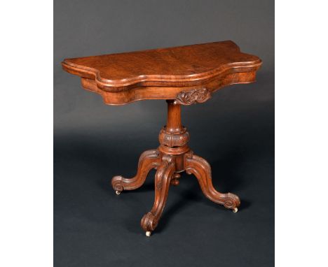 A Victorian walnut serpentine card table, folding top enclosing an inset baize-lined playing surface, above a deep frieze cen