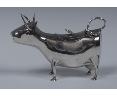 A Continental silver novelty cow creamer, hinged cover with applied butterfly finial, her swishing tail forming a loop handle