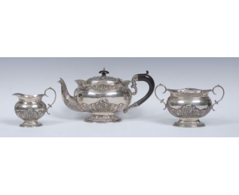 An Edwardian silver three piece oval boat shaped bachelor's tea service, comprising teapot, milk jug and sugar basin, part-fl