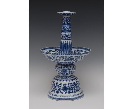 A late 19th century Chinese oil lamp, with tall column and dished bowl, domed base, decorated in underglaze blue with lotus, 