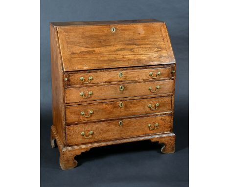 A George III elm bureau, fall front enclosing a cupboard, pigeon holes and small drawers, above four long graduated faux cock
