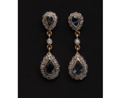 A pair of sapphire and diamond drop earrings, central tear drop blue sapphire, surrounded by thirteen round cut diamonds, sin