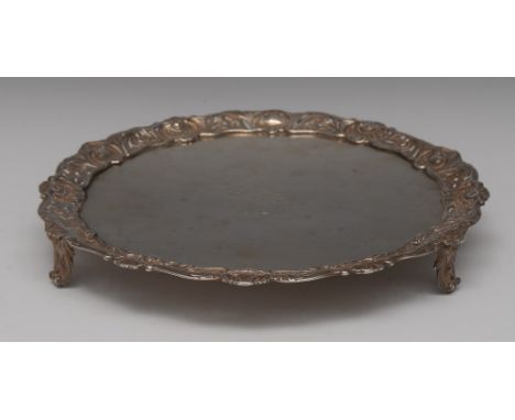 An early George III silver shaped circular salver, plain crested field, the applied border pierced and cast with shells and l