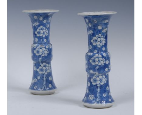 A pair of Chinese Gu vases, decorated with blossoming prunus, on a light blue ground, 20cm high, four character marks, Kangxi